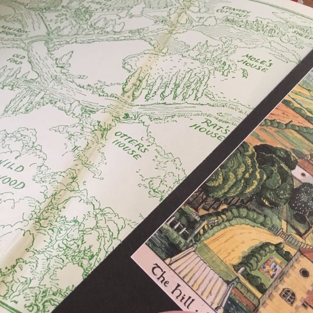 The inside covers of The Wind in the Willows and The Hobbit both show landscapes/maps featuring trees, fields and houses